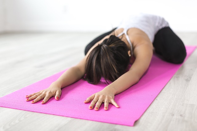 Frau in der Yoga Pose Balasana (Kind Position)
